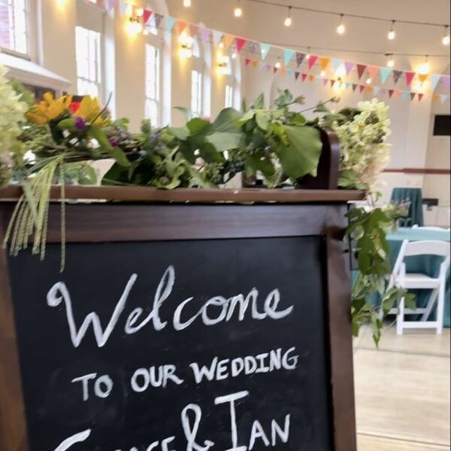 Chalkboard sign welcoming guests to a wedding reception where a typewriter poet wrote poems