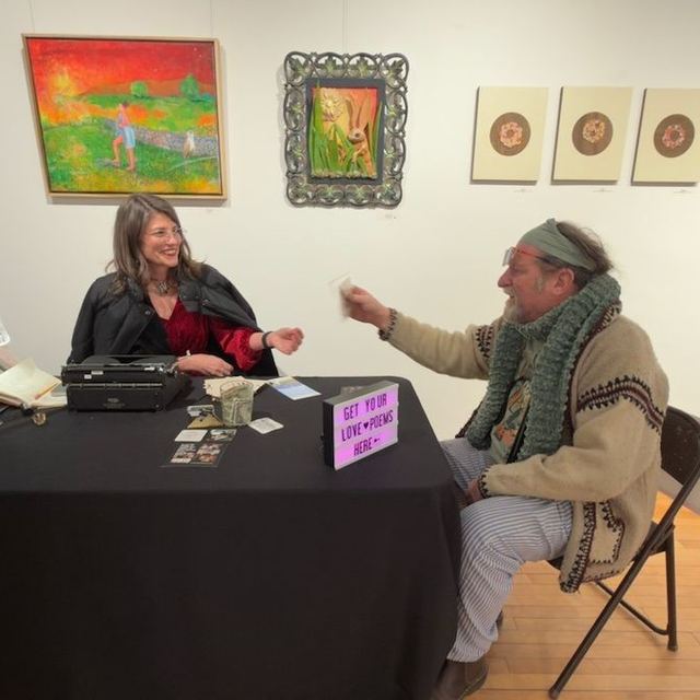 Typewriter poet handing a finished poem to a guest at a gallery event