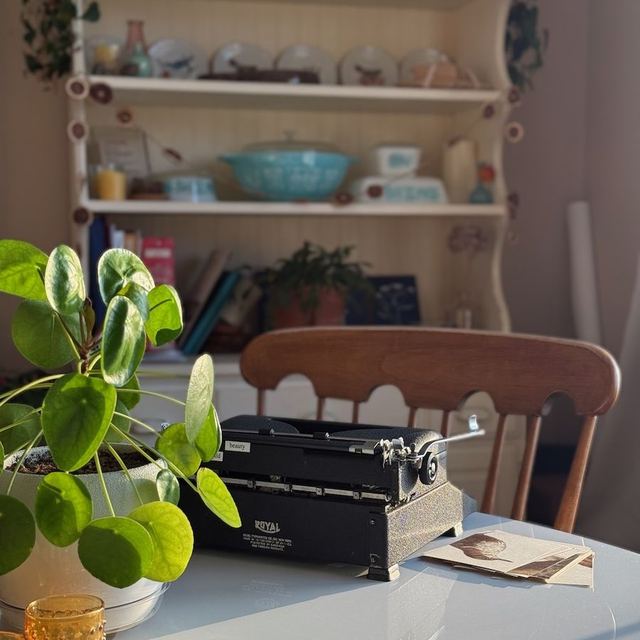 Vintage Royal portable typewriter on a kitchen table beside a plant